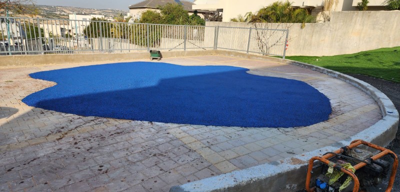 הכנת משטח גומי כחול בחצר חיצונית לפני השלמת העבודה